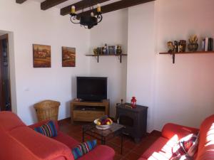 エル・ペドロソにあるLa Casita Moraのリビングルーム(赤いソファ、テレビ付)