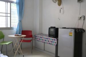 a small room with a refrigerator and a table at J Home apartment Hadyai in Hat Yai