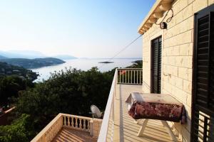 uma varanda com uma mesa e vista para a água em Diving Apartments em Molunat