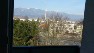 a window with a view of a building and a mountain at Byt v centre mesta Martin in Martin