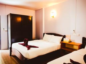 una camera d'albergo con due letti con scarpe sopra di Ban Tai Resort a Baan Tai