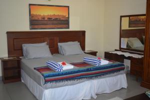 a bedroom with a bed with two towels on it at Janishi Residencies in Negombo