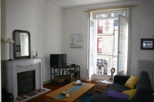 a living room with a couch and a fireplace at ville Pépin in Saint Malo