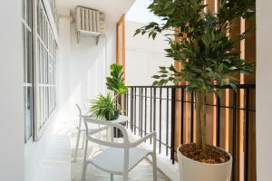 a balcony with a white chair and potted plants at The Pattern Boutique Hotel in Bangkok