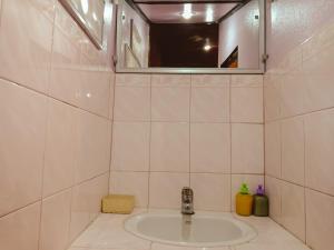 Ban Tai Resort في بان تاي: حمام من البلاط الأبيض مع حوض ومرآة +54 صورة