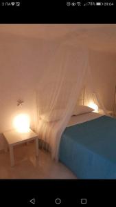 a bed with a canopy and a table with a light at Casa Vacanza La Conchiglia in Monopoli