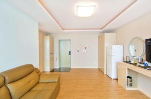 a living room with a couch and a refrigerator at Hotel Lohas in Boryeong