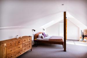 a bedroom with a bed and a wooden dresser at Hotel Anna in Stendal