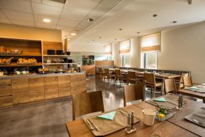 a restaurant with wooden tables and chairs and a kitchen at Hotel der Freiraum in Güssing