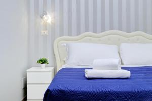 a bedroom with a blue bed with a white headboard at Domus Domas - Golden Keys Collection in Rome