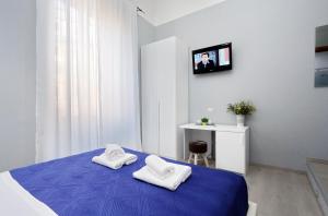 a bedroom with a blue bed with towels on it at Domus Domas - Golden Keys Collection in Rome