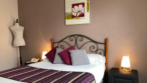 Schlafzimmer mit einem Bett mit roten und weißen Kissen in der Unterkunft Logis Hôtels - Hôtel et Restaurant Les Cordeliers in Casteljaloux