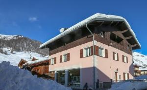 a building with snow on the ground in front of it at Appartamenti Guana in Livigno