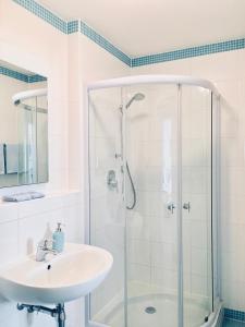 a white bathroom with a shower and a sink at Ferienwohnungen Birkenhof in Bad Wörishofen +7 photos