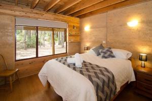 
A bed or beds in a room at Woodstone Kookaburra Cottage

