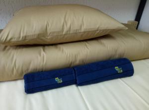 a bed with a pillow and a blue bow tie at Hostel Svit Hub in Kamianets-Podilskyi