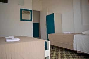 Habitación con 2 camas y puerta azul en Il piccolo attico in centro, en Pozzallo