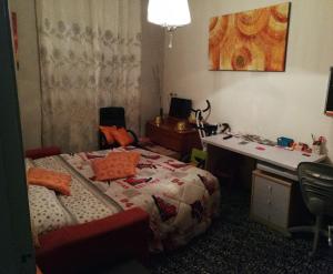 キアーヴァリにあるAppartamento Porzione di villa "il cappello d'oro"のベッド、デスク、デスクが備わる客室です。
