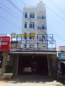 a building with a sign on top of a garage at Y Bon in Phan Thiet