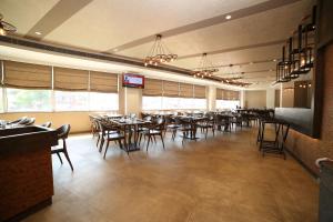 ein Speisesaal mit Tischen und Stühlen in einem Restaurant in der Unterkunft Native INN By Heda Hospitality in Belgaum