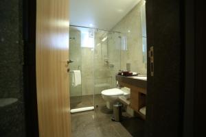 ein Badezimmer mit Toilette und Glasdusche in der Unterkunft Native INN By Heda Hospitality in Belgaum