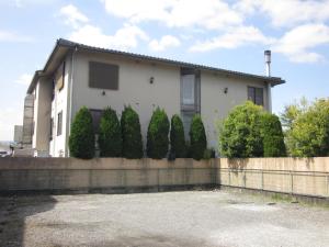 a white house with a fence and trees at Hotel Essor (Adult Only) in Nara