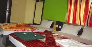 two beds sitting next to each other in a room at Hotel Srikrishna International in Tarapith