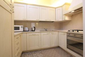 cocina con armarios blancos y microondas en Camilla apartment in Venice-Molino en Venecia