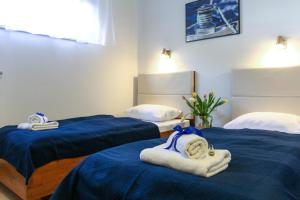 two beds in a room with blue sheets and towels at Apartamenty w Marina Jastrzębia Góra in Jastrzębia Góra +37 photos