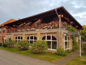 ein Gebäude mit einem Balkon mit Blumen darauf in der Unterkunft Hotel Da Gianni GmbH in Oranienburg