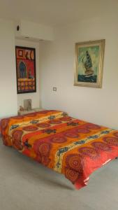 a bedroom with a large bed with a colorful blanket at Casa Isabelle Mel in La Spezia
