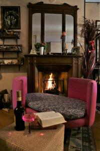a living room with a fireplace and a bench with a book at Chez Serena in Villafranca Piemonte