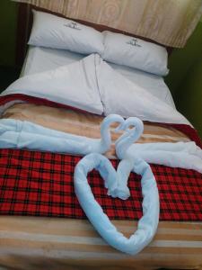 two swans made to look like hearts sitting on a bed at The Coconut Palm Hotel in Ndaragwa