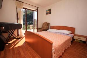 1 dormitorio con cama y piano junto a una ventana en Robinson Torac en Gdinj