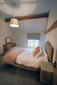sypialnia z dużym łóżkiem i oknem w obiekcie Honeysuckle Cottage, Drift House Holiday Cottages w mieście Astbury