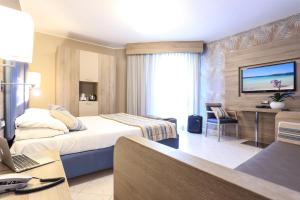 a hotel room with a bed and a desk at Alma di Alghero Hotel in Alghero