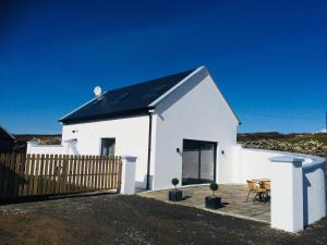 a white house with a black roof at Beside the sea & minutes from Cliffs-Clahane Shore Lodge in Liscannor