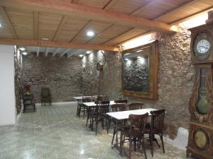 un restaurante con mesas y sillas y un reloj en Hostal Cal Pla, en Sant Llorenç Savall