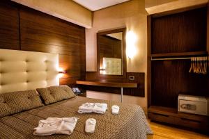 una camera da letto con un letto con asciugamani sopra di Nafs Hotel a Nafpaktos