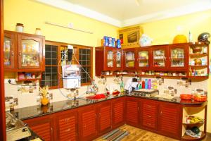 a kitchen with wooden cabinets and a counter top at Mom&Pop Thyparambil Heritage in Alleppey