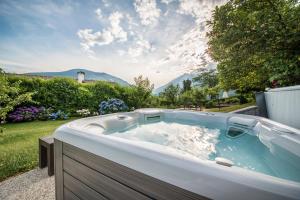 uma banheira de hidromassagem num quintal com jardim em Boutiquehotel Minigolf em Tirolo