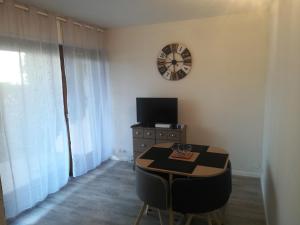 a room with a table and a clock on the wall at Le Cosy in Thonon-les-Bains