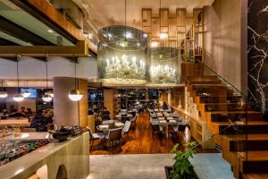 a dining room with tables and chandeliers at Nafs Hotel in Nafpaktos