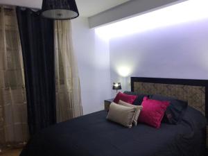 アレーナス・デ・サン・ペドロにあるApartamentos Las Ferreriasのベッドルーム(青いベッド、赤と白の枕付)