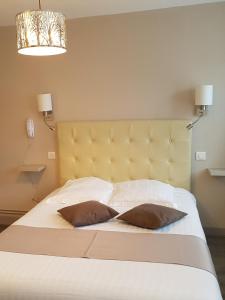 een slaapkamer met een bed met 2 kussens erop bij Hôtel Normand Yport Hôtel Ambiance familiale non étoilé in Yport