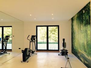a gym with exercise equipment and a large window at Barcelona Rooms in Mikoszewo
