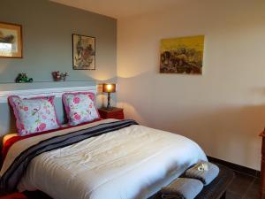 a bedroom with a large bed with pink pillows at Gîte L'Appart de Case Vanille in Sari Solenzara