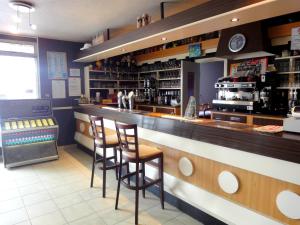 a bar in a restaurant with two stools at Hotel Restaurant La Grenouillère in Vitré