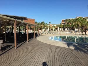 a patio with a pool and chairs and a building at Herdade dos Salgados Vila das Lagoas in Albufeira