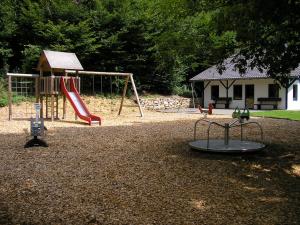 a playground with two swings and a slide at Ferienwohnung Thömmes in Gräfendhron